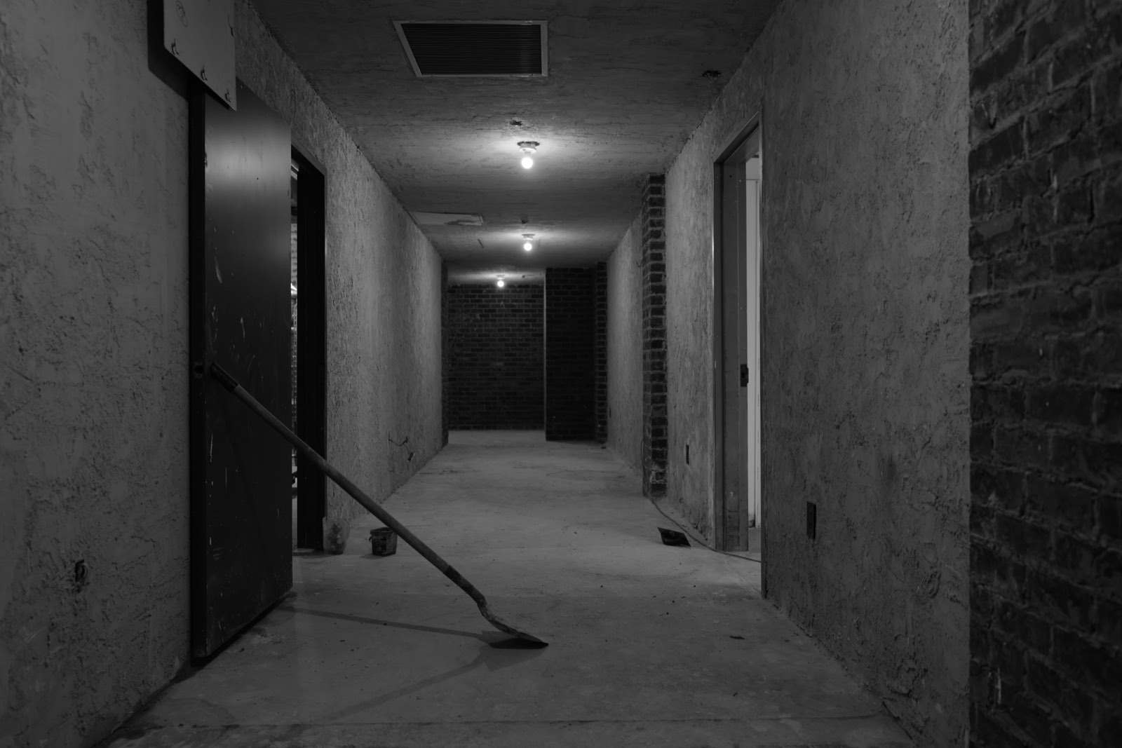 The corridor with an exposed brick wall at the end