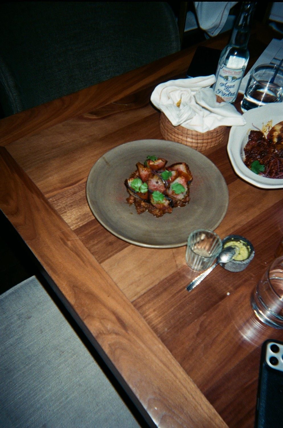 Un plato de barro servido sobre la mesa de nogal del comedor